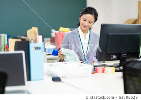 中年老師在職員室看文件 63308629