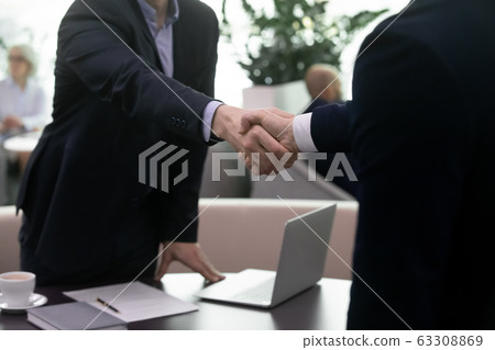 Successful businessmen shake hands closing deal after meeting Successful businessmen shake hands closing deal after meeting 63308869