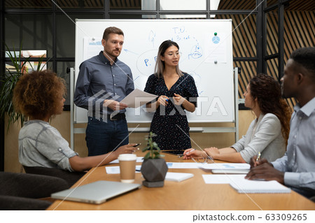 Diverse business coaches answering employees questions at briefing Diverse business coaches answering employees questions at briefing 63309265