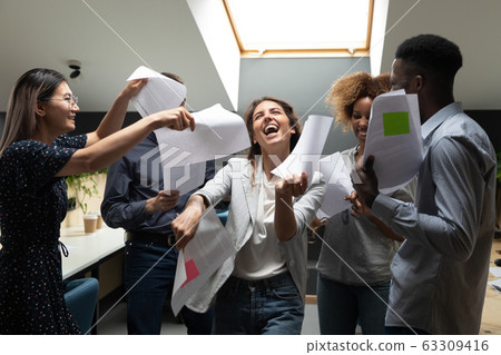 Happy excited diverse employees dancing with documents, celebrating success Happy excited diverse employees dancing with documents, celebrating success 63309416