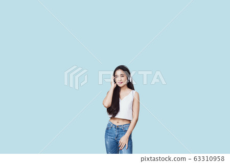 Young asian woman listening to music wearing 63310958