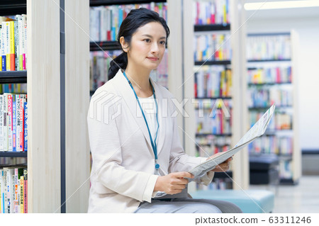 中年婦女在圖書館看報紙 中年婦女在圖書館看報紙 63311246
