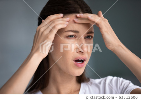 Stressed frustrated young woman worrying about skin problems. 63312606