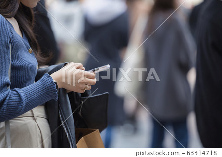 操作智能手機手的一個少婦 操作智能手機手的一個少婦 63314718