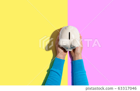 Person holding a piggy bank 63317046