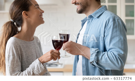 Close up happy loving couple clinking glasses of red wine 63317774