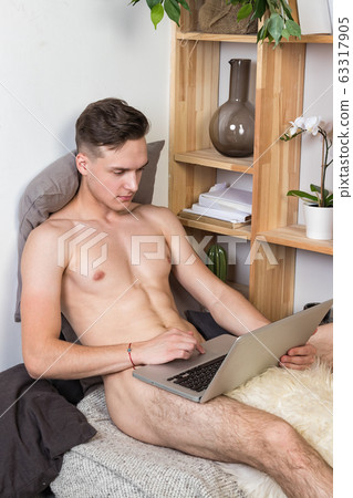 Naked sexy guy works at home with laptop 63317905