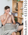 Naked sexy guy works at home with laptop 63317910