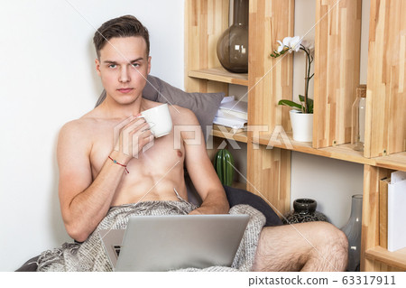 Naked sexy guy works at home with laptop 63317911