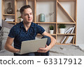 Young happy freelancer works at home with laptop 63317912