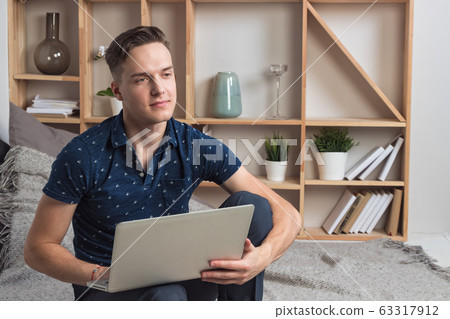 Young happy freelancer works at home with laptop 63317912