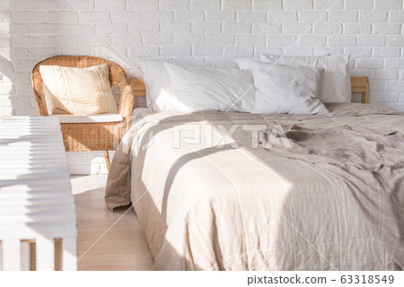 Home interior, bedroom in soft light colors with double bed, bedspread. pillows 63318549