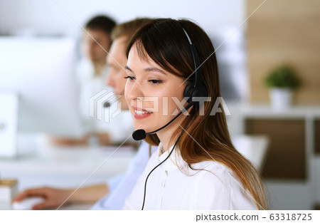 Call center. Group of diverse operators at work. Focus on beautiful asian woman in headset at customer service office. Business concept 63318725