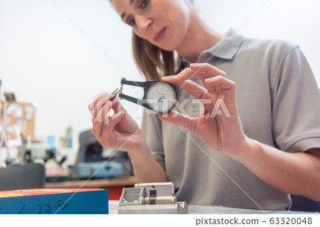 Woman locksmith repairing a lock 63320048