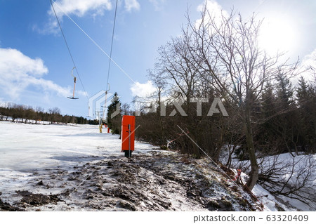 Stopped t-bar surface lift on empty ski slope, end of ski season concept, disappearing snow, sunny winter or spring day, Horni Mala Upa, Krkonose mountains, Czech Republic Stopped t-bar surface lift on empty ski slope, end of ski season concept, disappearing snow, sunny winter or spring day, Horni Mala Upa, Krkonose mountains, Czech Republic 63320409