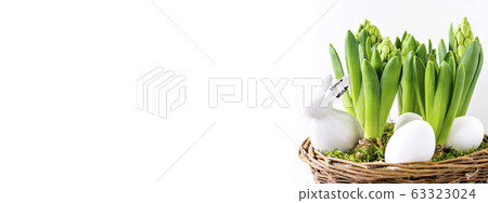 Cute white rabbit figurine in a basket. 63323024