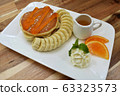 Pancakes with banana, orange sauce and caramel on wooden background 63323573