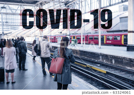 COVID-19 Text sign over travellers commuting at train station. Travel ban quarantine for public transport over Corona virus fear. Coronavirus panic social distancing people COVID-19 Text sign over travellers commuting at train station. Travel ban quarantine for public transport over Corona virus fear. Coronavirus panic social distancing people 63324061