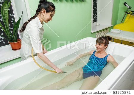 Woman in bath during hydrotherapy in beauty spa 63325871