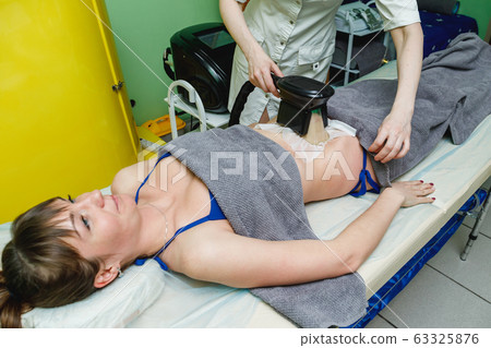 Woman getting cryolipolysis fat treatment in 63325876