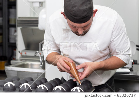 Professional confectioner making chocolate sweets at confectionery shop. Professional confectioner making chocolate sweets at confectionery shop. 63326737