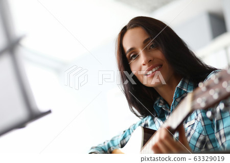 Playing acoustic instrument brings pleasure girl 63329019