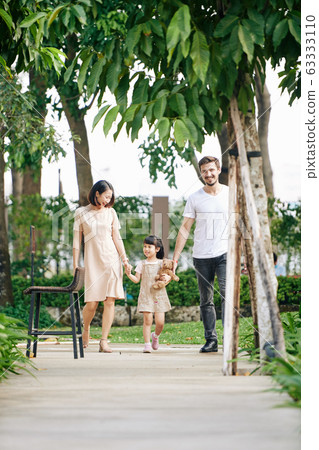Happy family walking in park Happy family walking in park 63333110