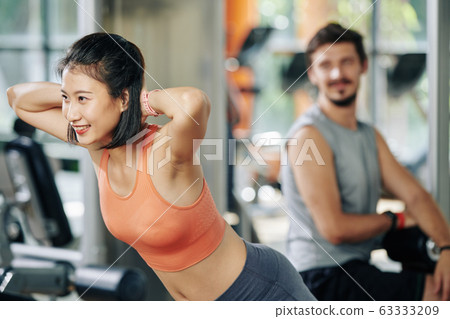 Woman exercising in hyperextension machine 63333209