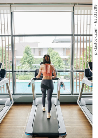 Woman walking on treadmill Woman walking on treadmill 63333299