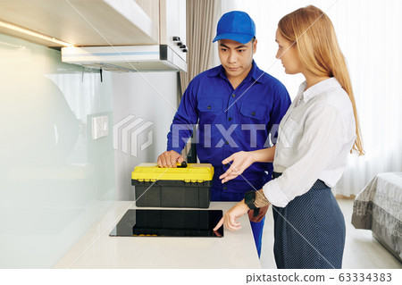 Woman talking to electrician Woman talking to electrician 63334383