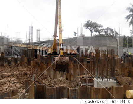 Temporary sheet pile cofferdam retaining wall at the construction site. It is installed to allow soil excavation and foundation work start. Temporary sheet pile cofferdam retaining wall at the construction site. It is installed to allow soil excavation and foundation work start. 63334408