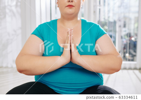 Meditating overweight woman Meditating overweight woman 63334611