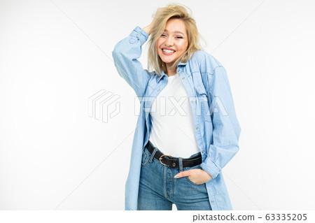 young blond woman in a cool blue shirt on an isolated white studio background young blond woman in a cool blue shirt on an isolated white studio background 63335205