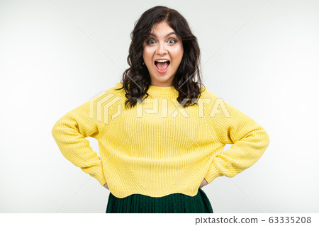 joyful brunette girl in a yellow sweater and green skirt on a white background joyful brunette girl in a yellow sweater and green skirt on a white background 63335208
