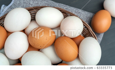 Chicken egg and duck egg on a black wooden table. Chicken egg and duck egg on a black wooden table. 63335773