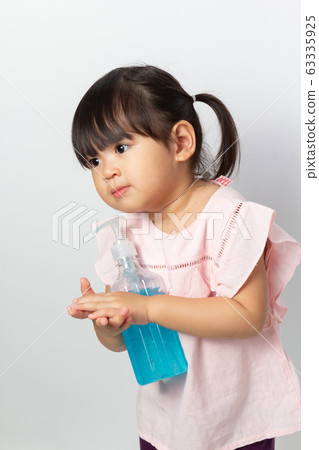 Asian girl using alcohol antiseptic gel for 63335925