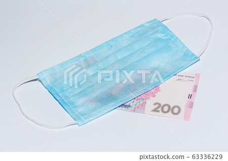 Protective medical mask and Ukrainian hryvnia. 63336229