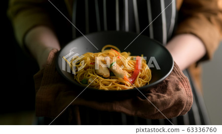 Close up view of a woman holding Schezwan Noodles Close up view of a woman holding Schezwan Noodles 63336760