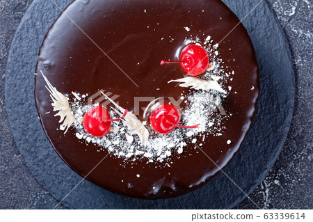 Chocolate and cherries cake on concrete background Chocolate and cherries cake on concrete background 63339614