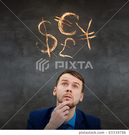 Businessman looking up on fire glowing currency signs. Businessman looking up on fire glowing currency signs. 63339786