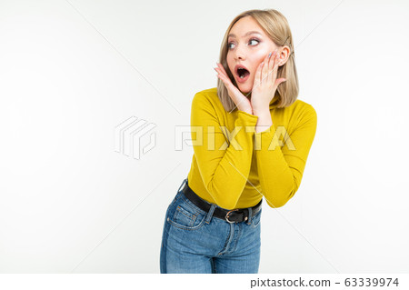 surprised girl in a lemon turtleneck and jeans posing on an isolated white background with copy surprised girl in a lemon turtleneck and jeans posing on an isolated white background with copy 63339974
