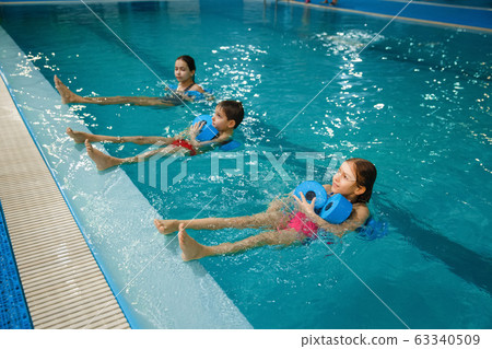 Children swimming group, workout with dumbbells Children swimming group, workout with dumbbells 63340509