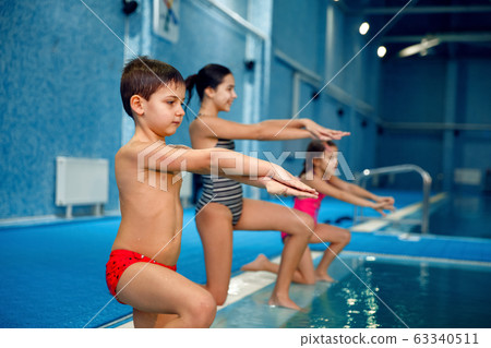 Children swimming group, workout at the poolside Children swimming group, workout at the poolside 63340511