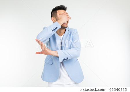 a man in a blue classic jacket closes his hand and asks to remove something on a white background 63340535