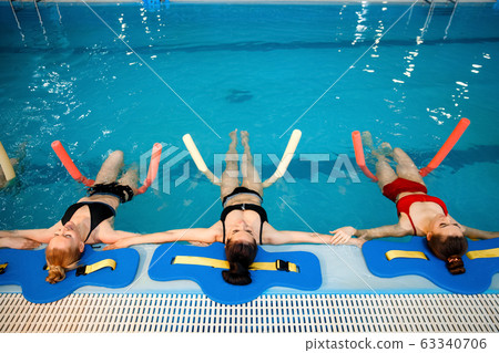 Female swimmers, aqua aerobics at the poolside Female swimmers, aqua aerobics at the poolside 63340706