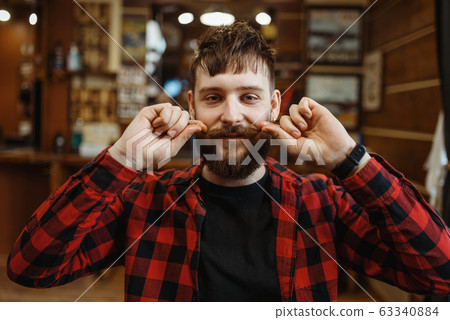 Barber twists his mustache, retro style barbershop 63340884