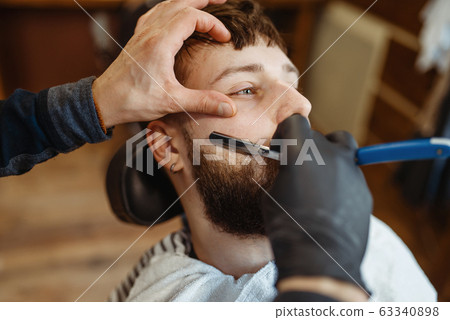 Barber with razor, old school beard cutting Barber with razor, old school beard cutting 63340898