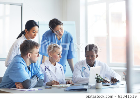 Group of Doctors Using Laptop Together Group of Doctors Using Laptop Together 63341519