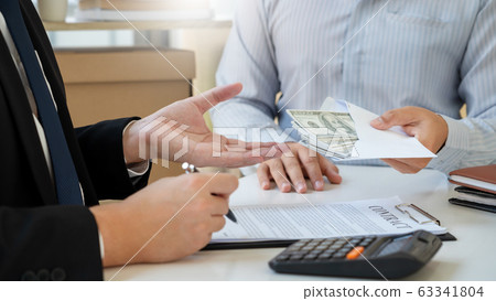 Businessman giving bribe money dollar banknotes in 63341804