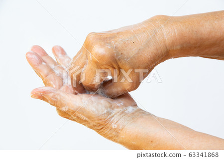 Senior woman's hands washing her hands using soap foam in step 6 on white background, Close up & Macro shot, Selective focus, Prevention from covid19, Bacteria, healthcare concept, 7 step wash hand Senior woman's hands washing her hands using soap foam in step 6 on white background, Close up & Macro shot, Selective focus, Prevention from covid19, Bacteria, healthcare concept, 7 step wash hand 63341868